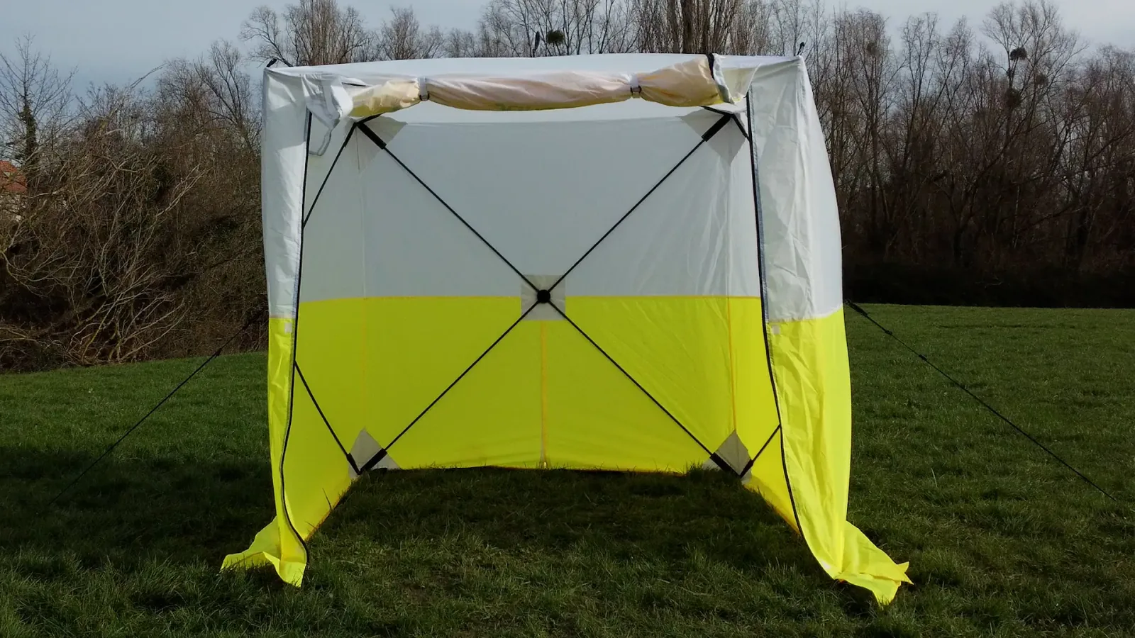 Tente de chantier JAX3 déployée sur l'herbe, haubans tendus